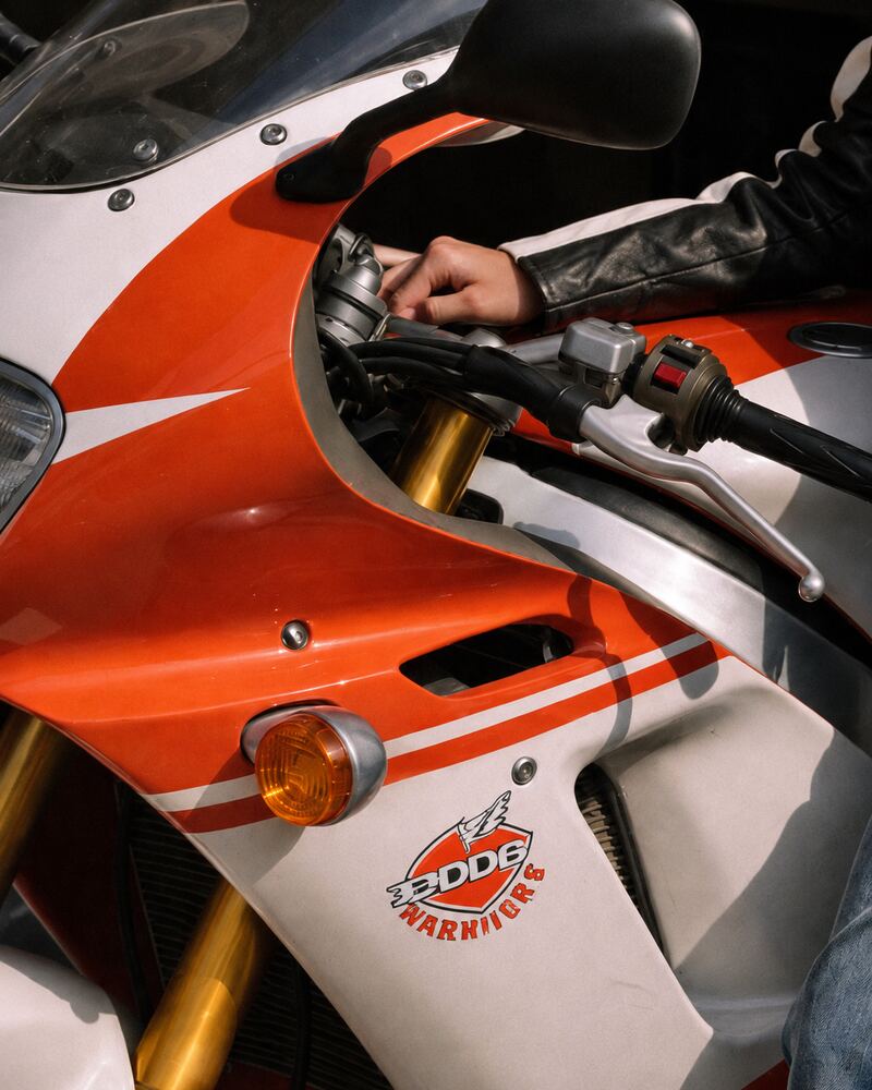 Femme avec la moto — Zoom : Carenage moto guidon main