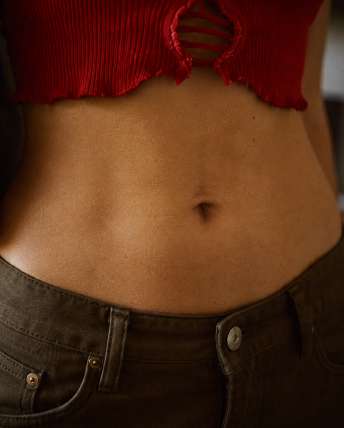 Portrait lifestyle féminin — Zoom : Ventre + top rouge usé