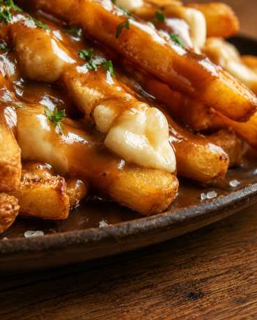 Poutine canadienne traditionnelle — Zoom : Frites croustillantes, sauce brune et fromage fondant