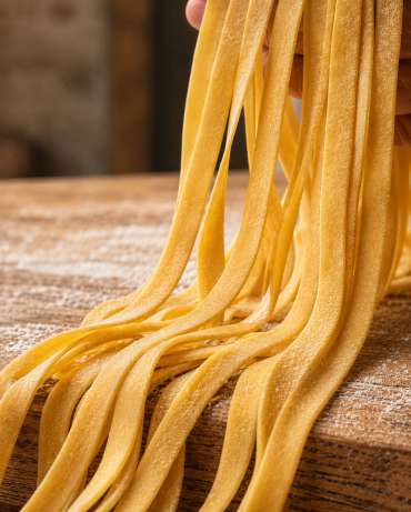 Préparation traditionnelle de pâtes italiennes — Zoom : Cascade de fettuccine fraîche